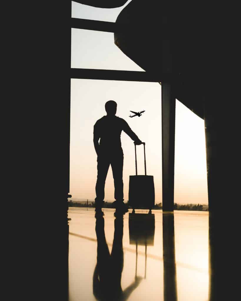 Person at the airport silhouetted by the sunset, able to travel thanks to a US Entry Waiver.
